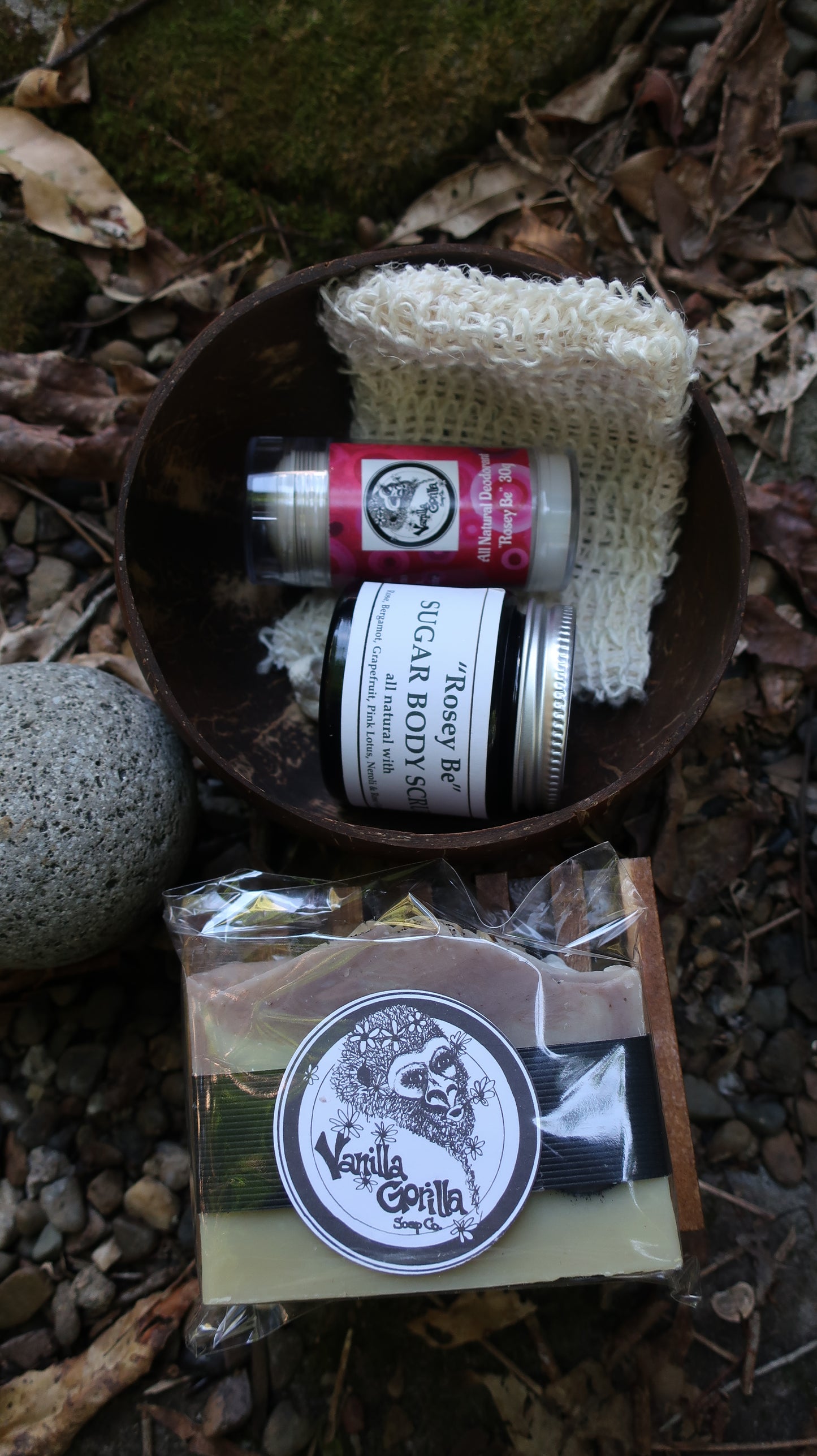 Skincare products including a jar of sugar scrub, soap, and deodorant on a natural background