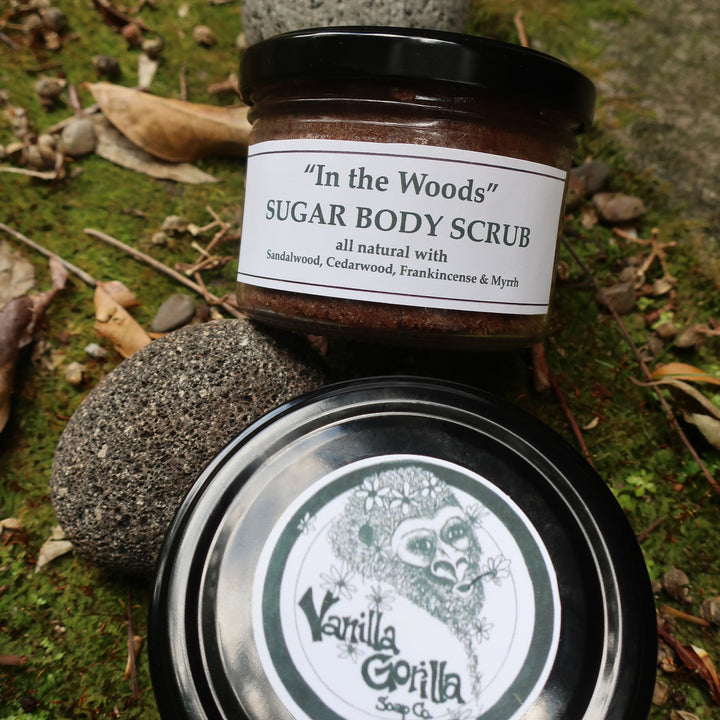 Jar of 'In the Woods' sugar body scrub with a labeled lid on a natural background