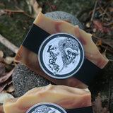 Two fizzy grapefruit bars of soap with black straps and branded labels on a natural background.