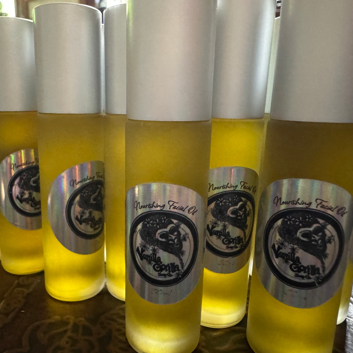 Bottles of Nourishing Facial Oil with visible labels on a wooden surface