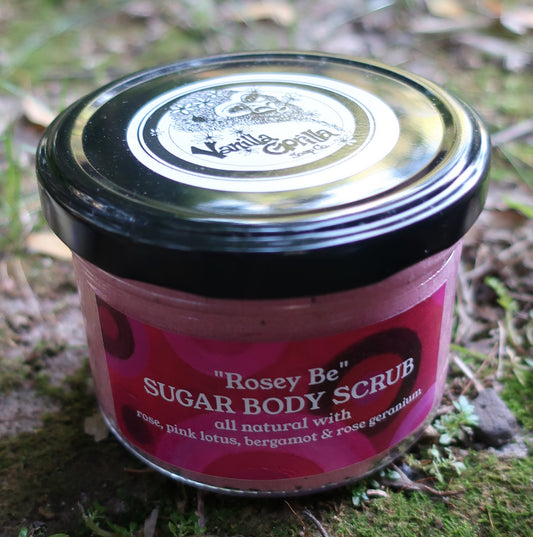 Pink jar of vanilla gorilla body scrub with black lid on a mossy rock