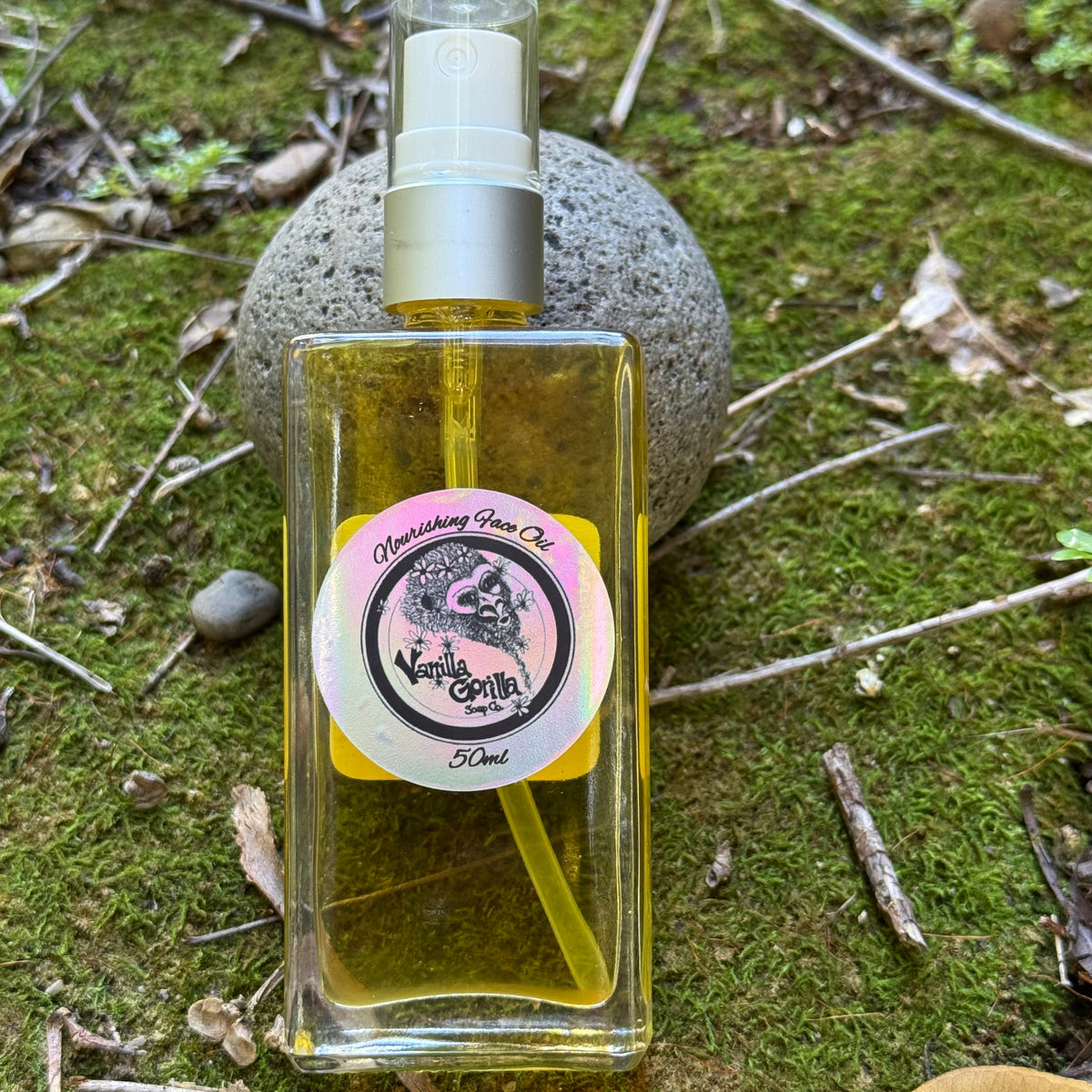 Clear bottle of face oil with a vanilla gorilla label on a natural background