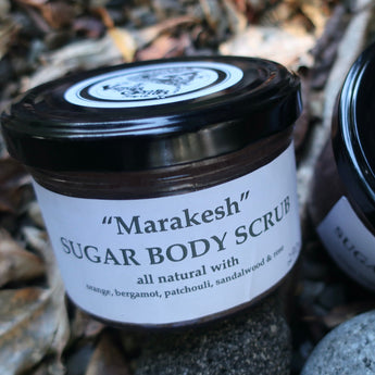Two jars of 'Marakesh' Sugar Body Scrub with visible branding on a natural background.