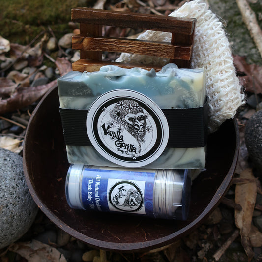 Vanilla Gorilla Silverback soap bar & bush baby deodorant in a coconut bowl on a textured surface with natural elements.