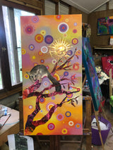 Colorful abstract painting of a brushtail possum with a stylized tree and geometric patterns on a wooden easel.