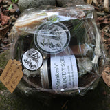 Jar of body scrub & raspberry soap on a wooden soap drainer & soap bag cello wrapped in a coconut bowl