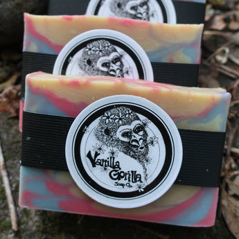 Three colorful love spell soap bars with a vanilla gorilla logo on a natural background