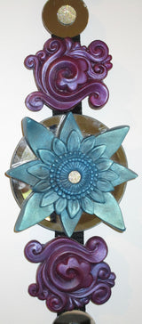 feng shui wall decor blue sculpted lotus centre surrounded by purple swirls and round mirrors