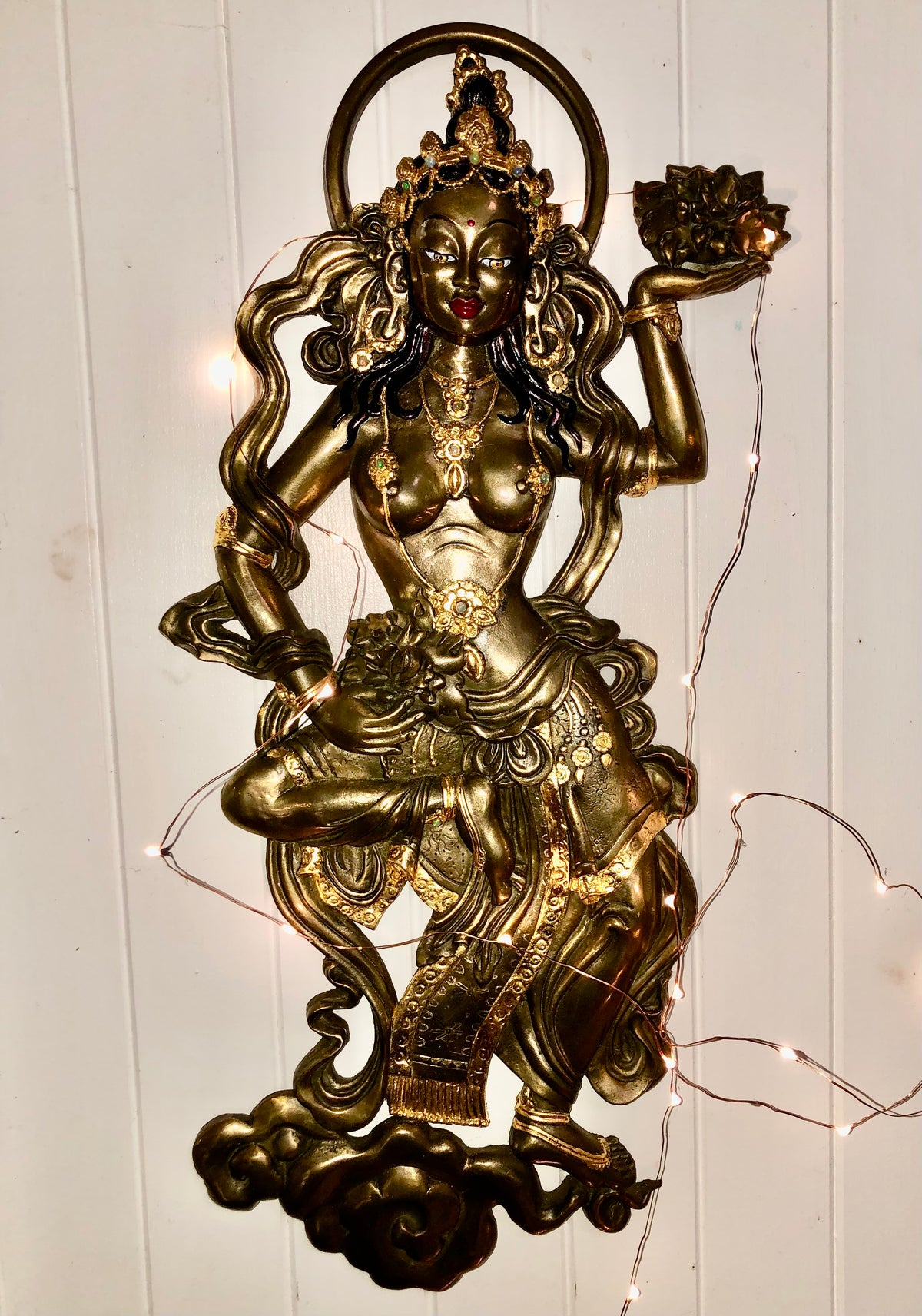 Bronze & Gold Offering Goddess on white wall with fairy lights